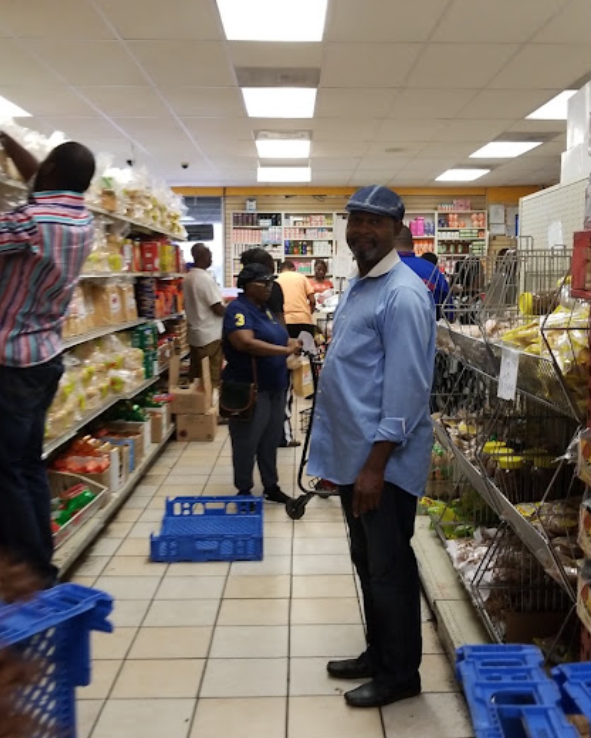 Friendly staff member helping shoppers in a stocked aisle