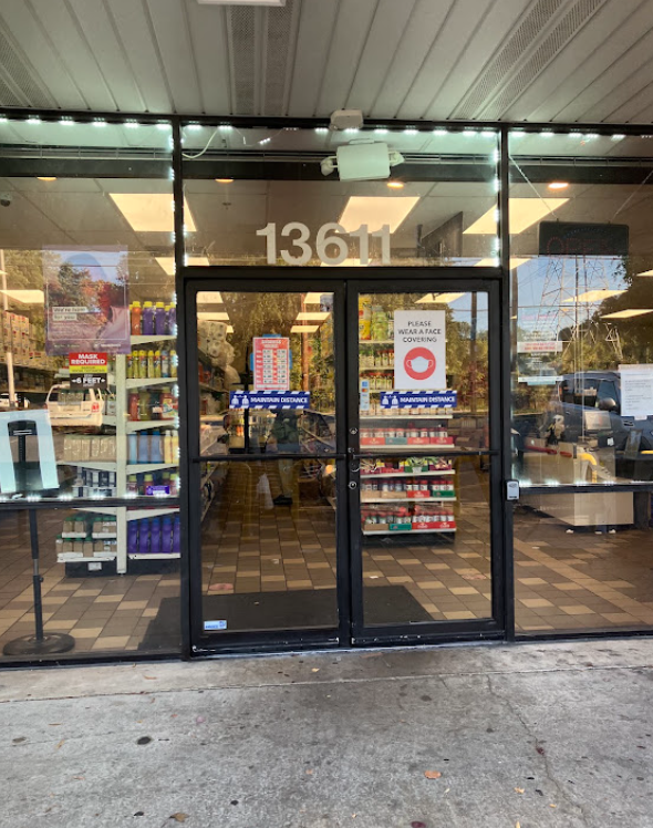 Glass entrance doors of the market with product shelves visible inside